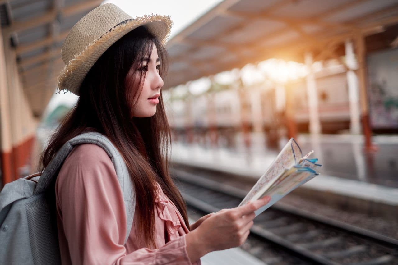A traveler with a small backpack looking at a city map