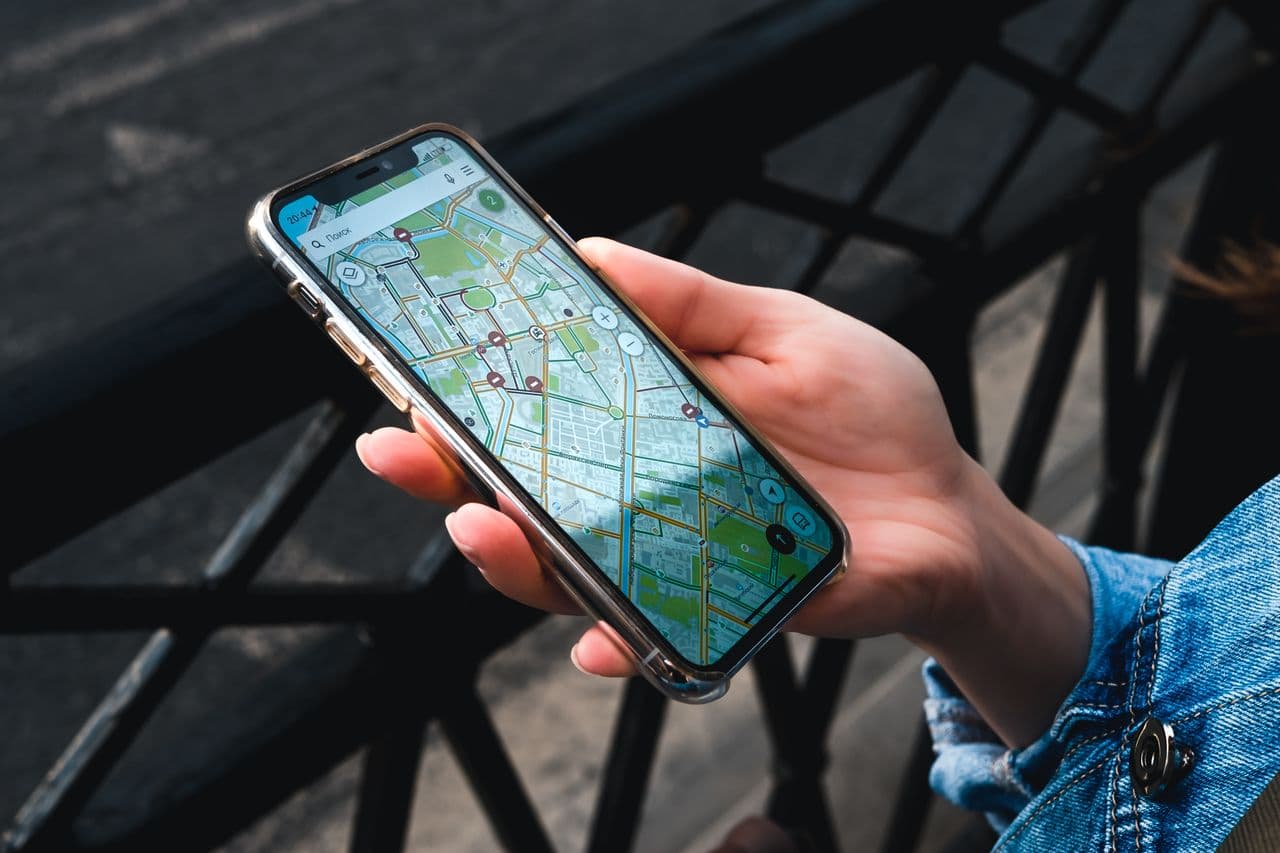 A traveler using a map app on a smartphone to find directions in a city