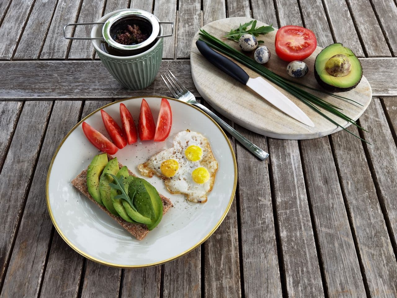 A simple healthy breakfast with eggs, fruit, oats, and a glass of water